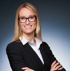 Person mit Brille im Anzug, lächelnd.