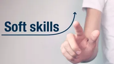 Person zeigt auf Text 'Soft skills' mit einem aufsteigenden Pfeil.