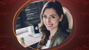 Person vor einem Computer mit Code auf dem Bildschirm.
