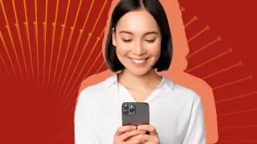 Person schaut auf ein Smartphone vor rotem Hintergrund.