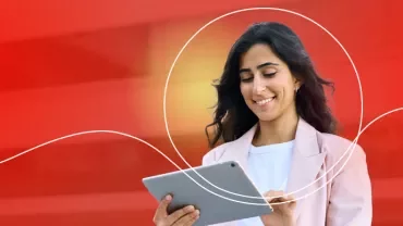 Person mit Tablet vor rotem Hintergrund.
