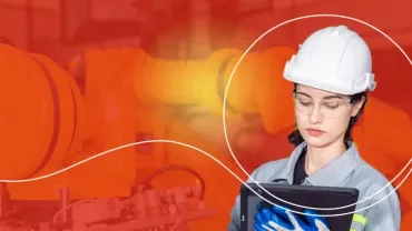 Person mit Schutzhelm und Tablet vor Industrieroboter
