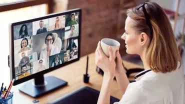 Eine Frau arbeitet im Homeoffice und hat eine Telefonkonferenz mit ihrem Team.