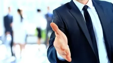 Eine Person reicht die Hand zum Handschlag.