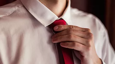 Person, die eine rote Krawatte richtet.