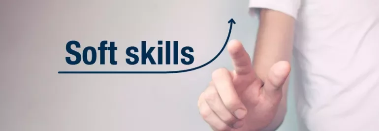 Person zeigt auf Text 'Soft skills' mit einem aufsteigenden Pfeil.