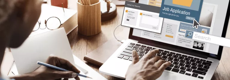 Person arbeitet an einem Laptop mit einer Jobbewerbung auf dem Bildschirm.
