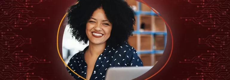 Lächelnde Person mit lockigem Haar, im Hintergrund unscharfes Bücherregal.