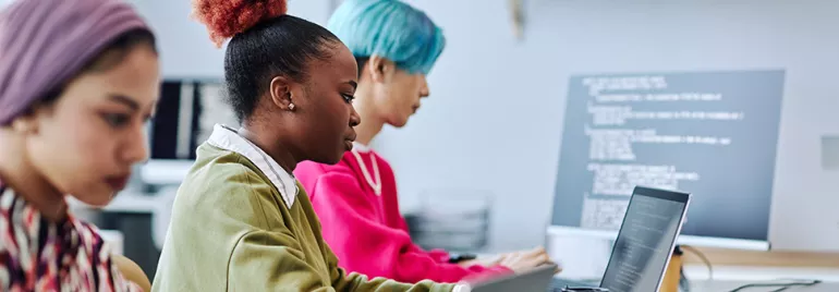 Personen arbeiten konzentriert an Laptops in einem modernen Büro.