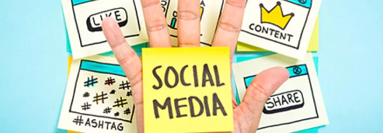 Hand mit Social-Media-Stickern, darunter Like und Share.