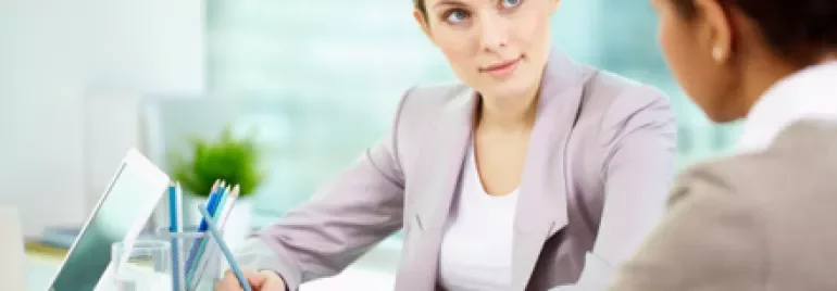 Zwei Personen in einem Büro bei einem Gespräch.
