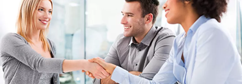 Gruppe von Menschen im Büro bei einem Meeting.