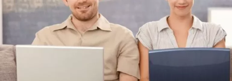 Zwei Personen arbeiten gemeinsam an Laptops.