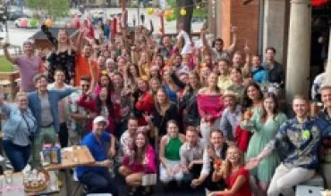 Eine große Gruppe von Menschen feiert draußen.