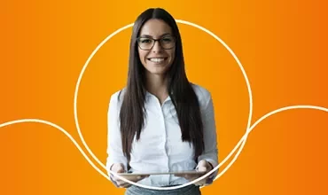 Person mit Brille hält Tablet vor orangefarbenem Hintergrund.